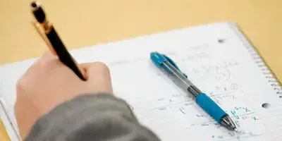 一只手在笔记本上写数学的特写